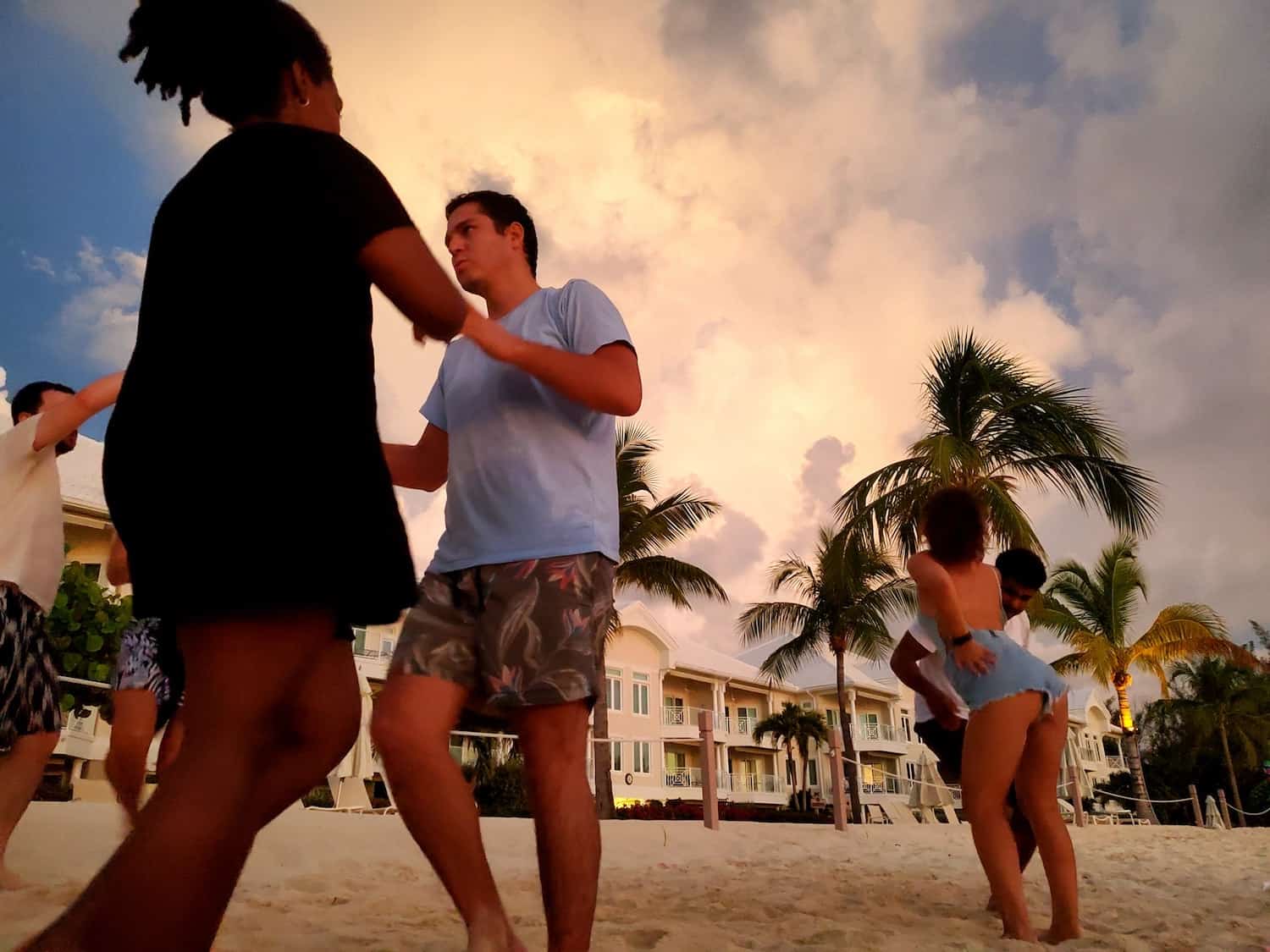 People dancing salsa on the beach in the Cayman Islands in front of a hotel