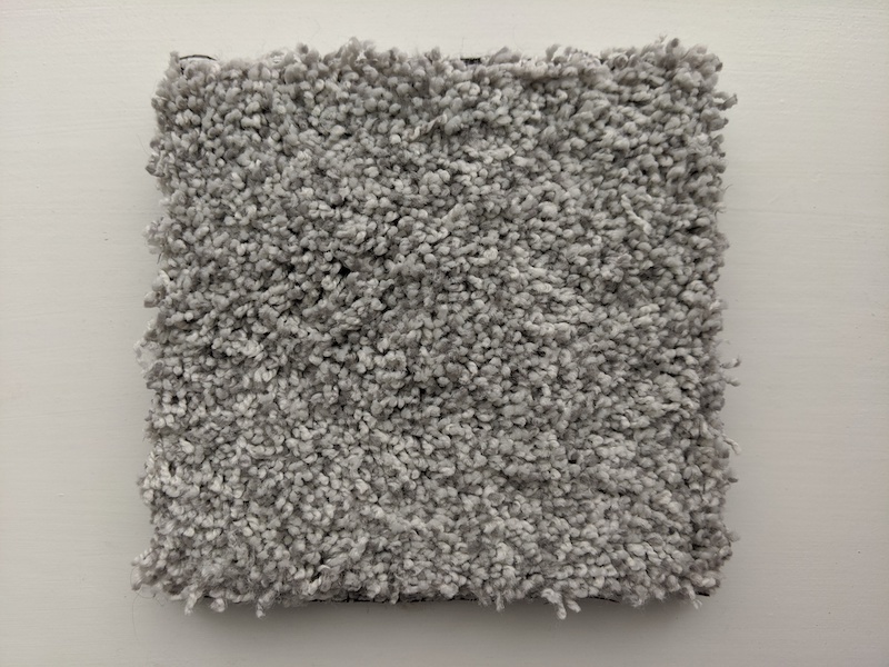 A square from the top of grey air.o polyester carpet that has a shaggy look