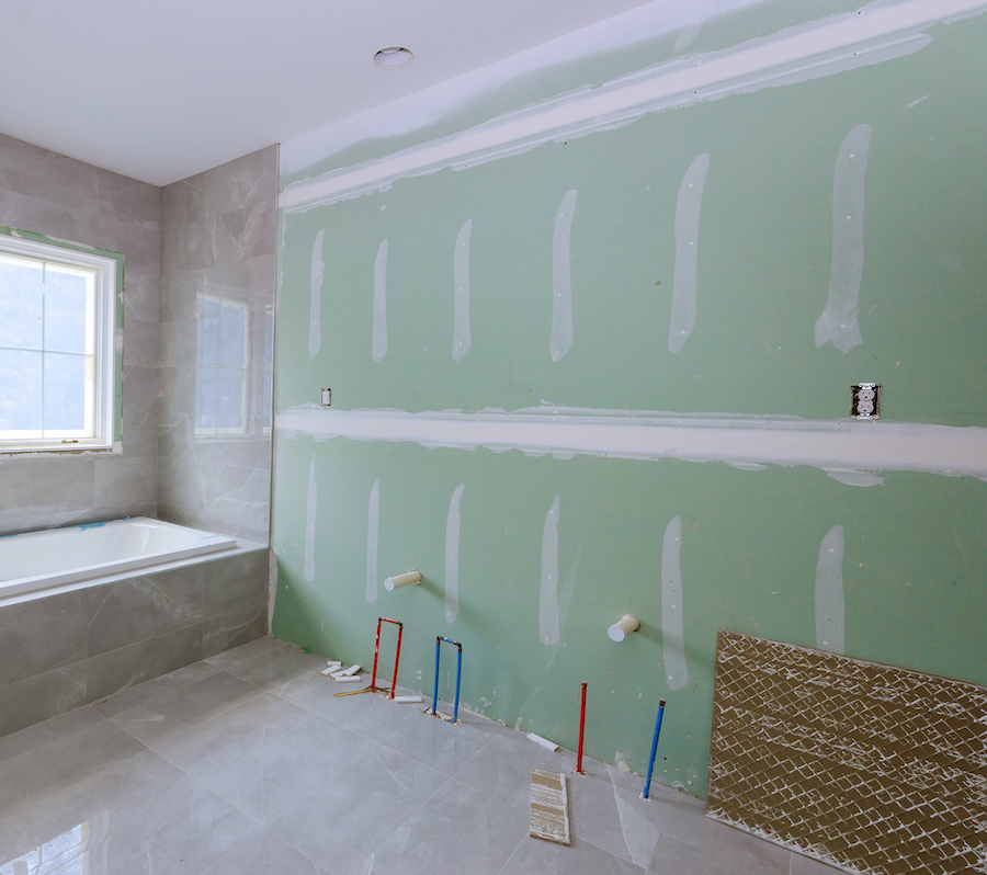 A bathroom with greenboard that is mudded at the seams but not yet painted