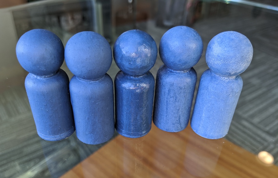 Bright blue Milk paint on 5 little wooden peg dolls, all showing the look of different top coats