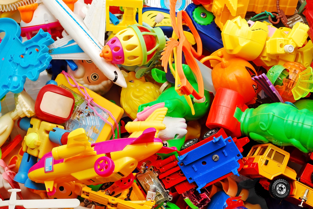 a bunch of small plastic toys thrown into a pile. they are bright colors like yellow, red, green, blue. 